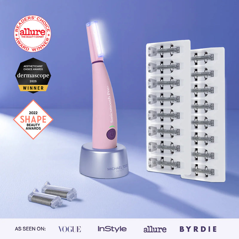 Pink The Michael Todd Beauty Sonicsmooth Pro+ System, a pink skincare device with sonic dermaplaning technology, is shown on its stand with refills, surrounded by award badges and magazine logos in the background.