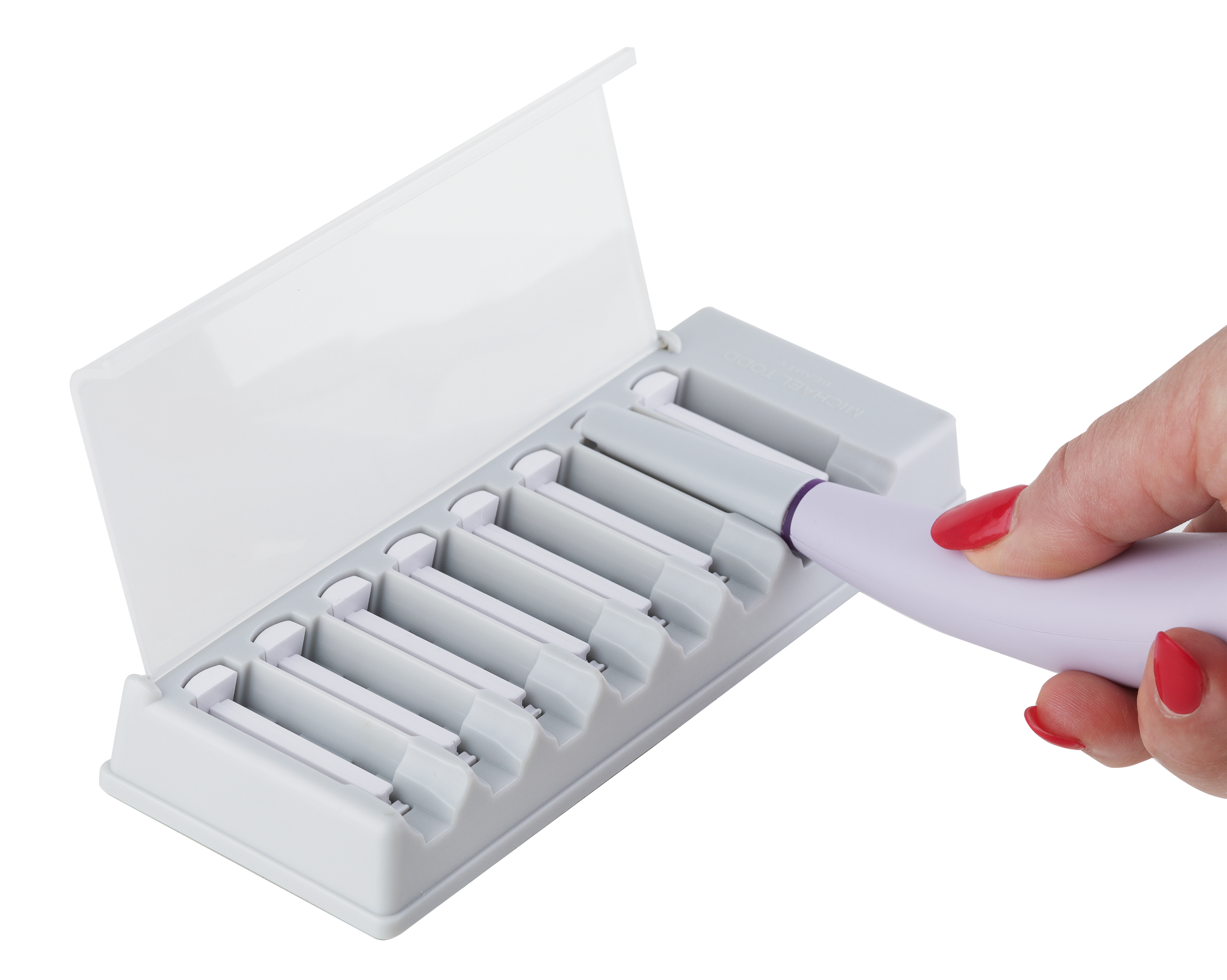 A hand with red nail polish holds a white pen-like Sonicsmooth tool near a tray of cylindrical Michael Todd Beauty Sonicsmooth Refill Tips in slots, one slot is empty.