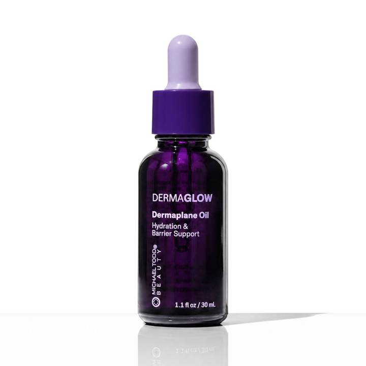 Dermaglow Dermaplane Oil by Michael Todd Beauty, 1.1 fl oz, features a lavender dropper cap and text on a translucent dark purple background.