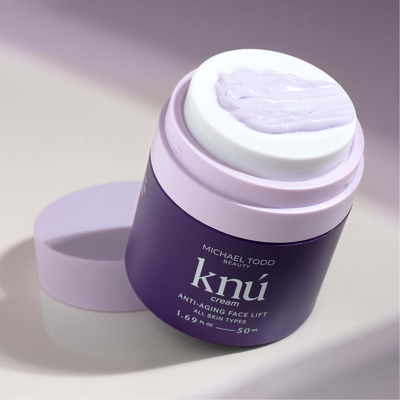 A jar of rejuvenating Knú Ageless Duo cream from Michael Todd Beauty sits on a white surface.
