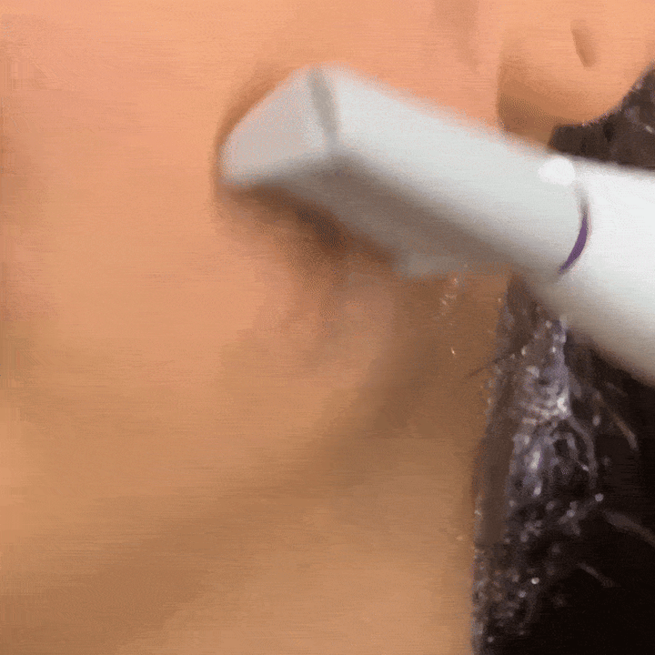 A close-up of a person using the Michael Todd Beauty Sonicsmooth Pro+ System for professional-grade exfoliation on their jawline.