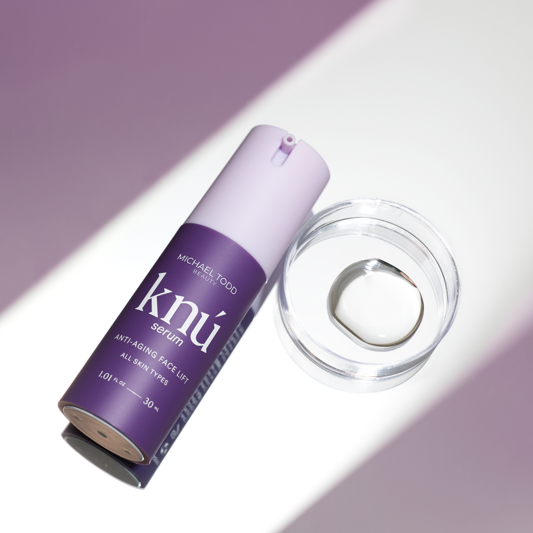 A bottle of Michael Todd Beauty's Knú Ageless System skincare serum with a ring next to it.